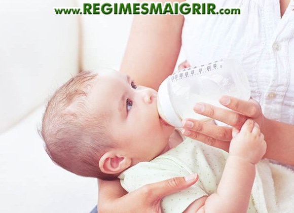 Une maman donne le biberon à son bébé qui lui regarde