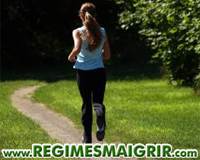 Une femme en train de faire du jogging dans la forêt