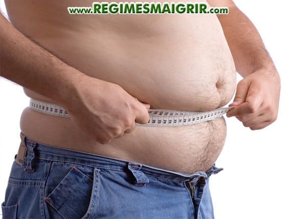 Un homme ayant un ventre dodu mesure son tour de taille