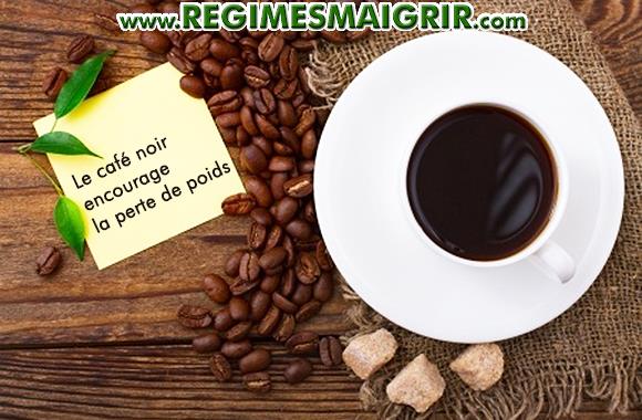 Une tasse de caf noir pose sur la table  ct des graines de caf et des morceaux de sucre brun