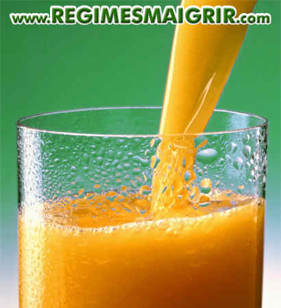 Du jus d'orange est versé dans un verre