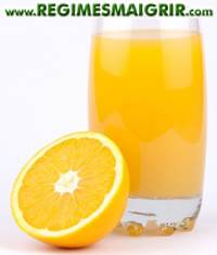 Un verre de jus d'orange frais pos  ct de cet agrume