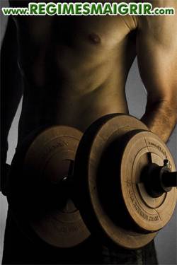 Homme en train de lever un haltre pour effectuer l'un des mouvements de musculation les plus simples qui soient