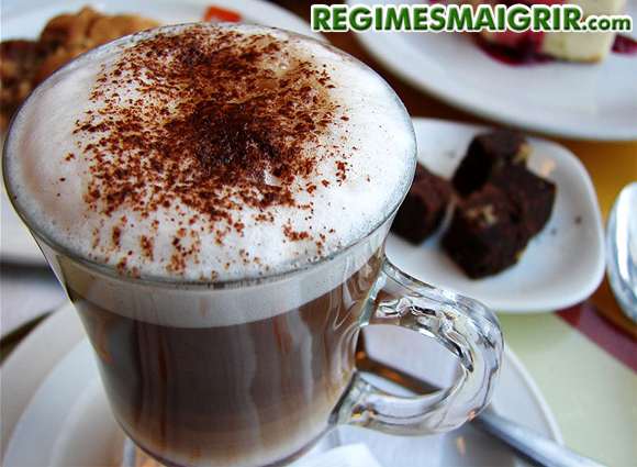 Une tasse de cappuccino pose sur la table  ct de diverses assiettes de chocolat et de gteaux