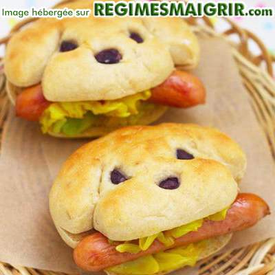 Dans un panier se trouvent 2 sandwiches en forme de tte de chien croquant chacun une saucisse