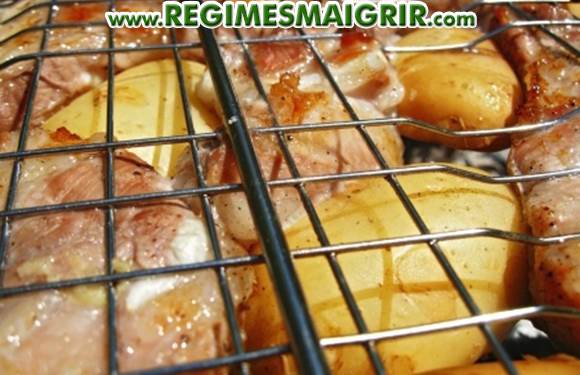Des patates avec leur peau sont grilles avec de la viande lors d'un barbecue