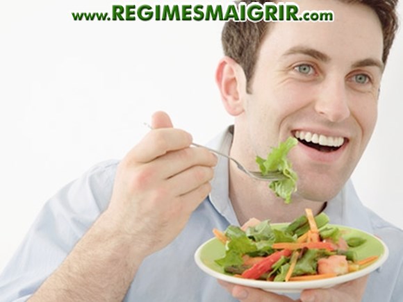 Un homme mange une salade qui est un plat sain typique