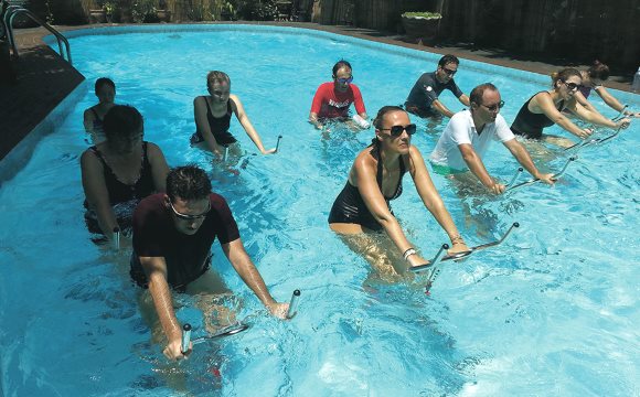 Un groupe de personnes pratiquent l'aquabiking dans une piscine