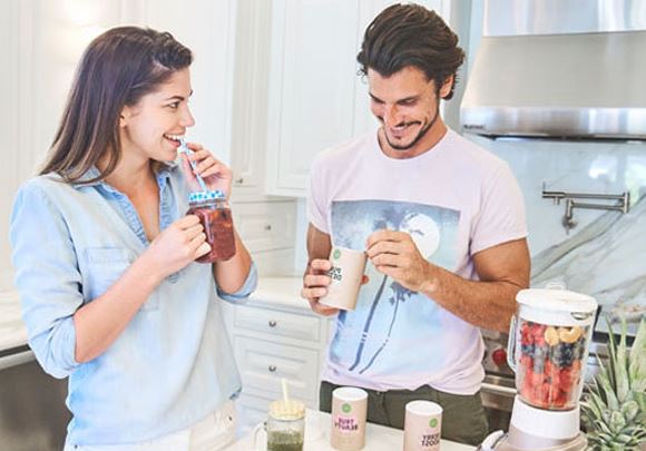 Un homme et une femme boivent des complments alimentaires sous forme de shake dans une cuisine