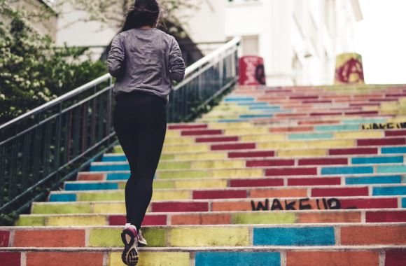 Une femme est en train de monter un escalier en courant