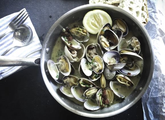 Des fruits de mer mis à côté d'une fourchette et d'une cuillère après avoir été bouillis