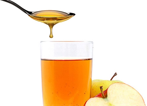 Une cuillre contenant du vinaigre de cidre est verse dans un verre contenant le mme liquide